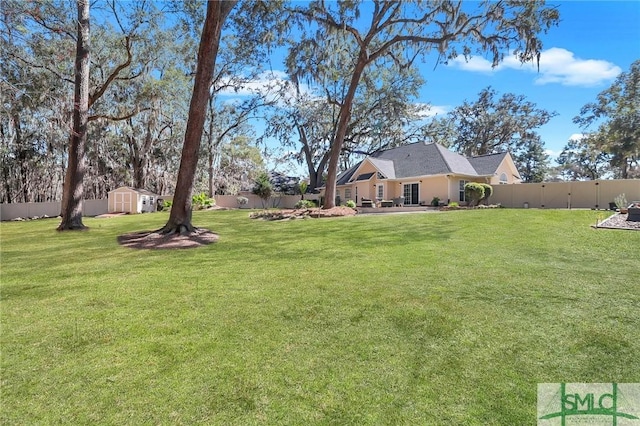 view of yard with a shed, an outdoor structure, and a fenced backyard