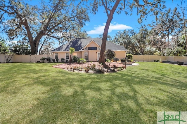 back of house featuring a yard and a fenced backyard