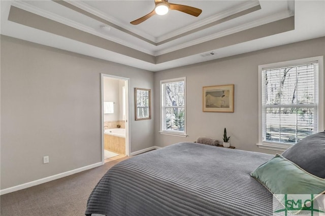 carpeted bedroom with ensuite bathroom, visible vents, baseboards, a raised ceiling, and crown molding