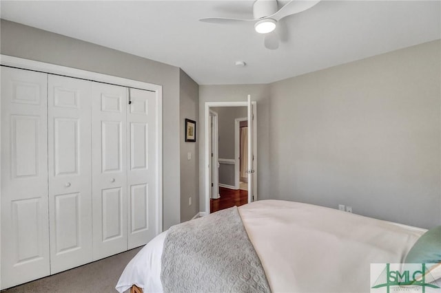 bedroom featuring a closet, dark carpet, and a ceiling fan