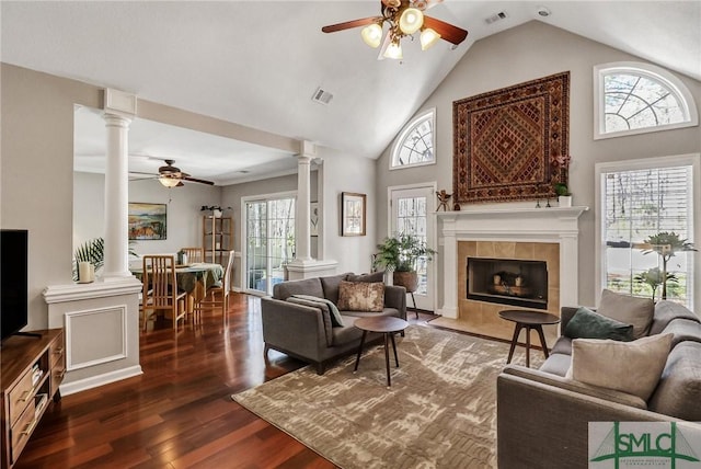 living area featuring visible vents, a fireplace, and decorative columns