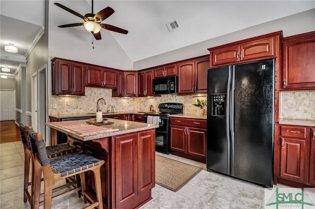 kitchen featuring black appliances, dark brown cabinets, a sink, and visible vents