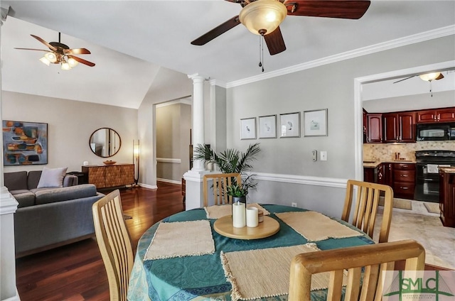 dining room featuring ceiling fan, wood finished floors, vaulted ceiling, decorative columns, and crown molding