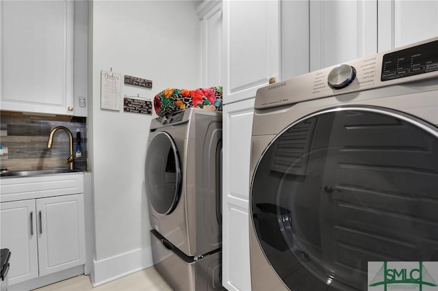 laundry room featuring cabinet space, washing machine and dryer, and a sink