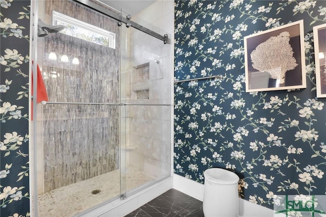 full bathroom with marble finish floor, a shower stall, baseboards, and wallpapered walls