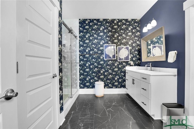 full bathroom with marble finish floor, a stall shower, vanity, baseboards, and wallpapered walls