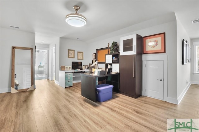 office space with light wood-style flooring, visible vents, and baseboards