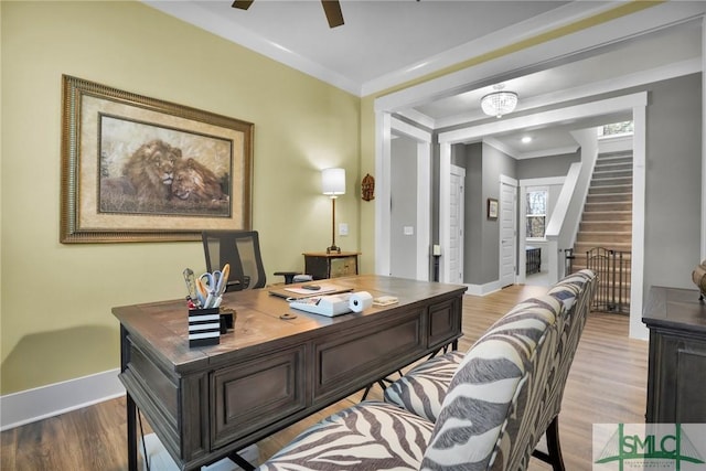 office space featuring light wood-style flooring, baseboards, and ornamental molding