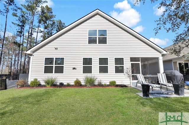 back of property with a lawn, a patio area, fence, and a sunroom