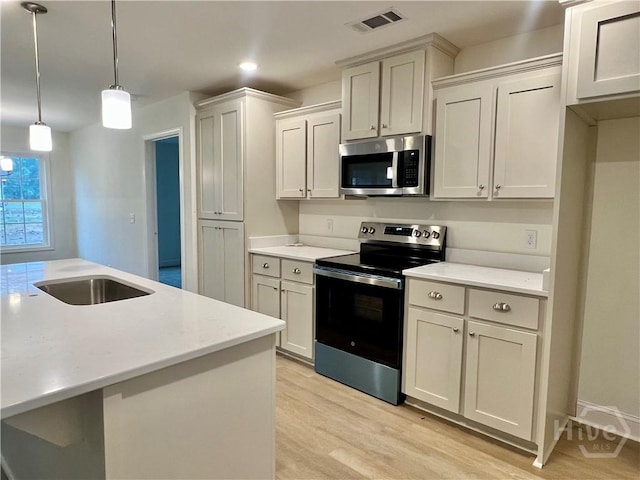 906 Coosa Cv, Ellabell, GA 31308 - kitchen with appliances with stainless steel finishes, light wood-type flooring, light countertops, decorative light fixtures, and recessed lighting
