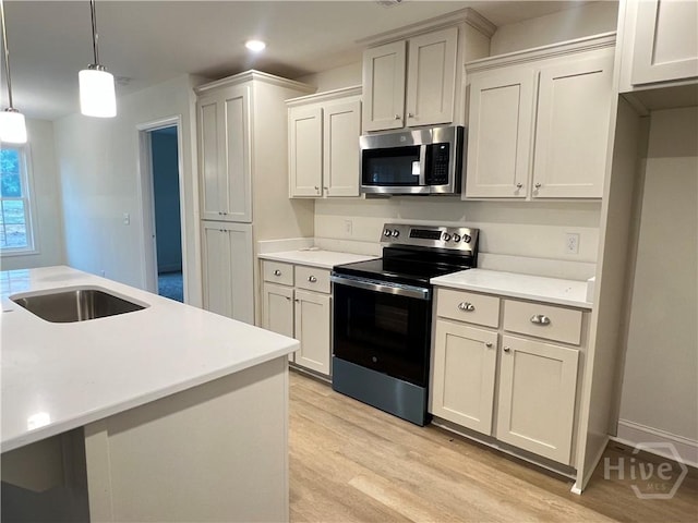 906 Coosa Cv, Ellabell, GA 31308 - kitchen featuring appliances with stainless steel finishes, light wood-style floors, light countertops, decorative light fixtures, and recessed lighting