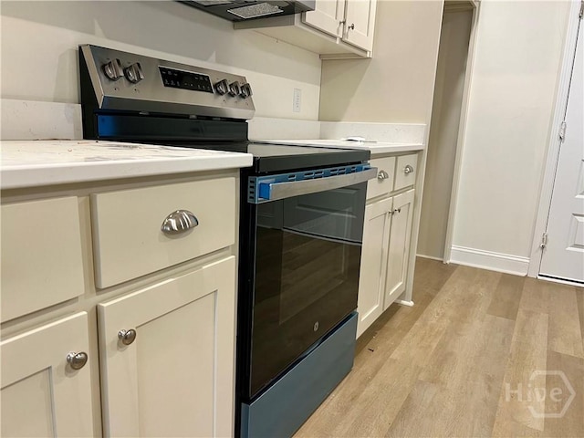 906 Coosa Cv, Ellabell, GA 31308 - kitchen featuring electric range, light wood finished floors, and white cabinetry