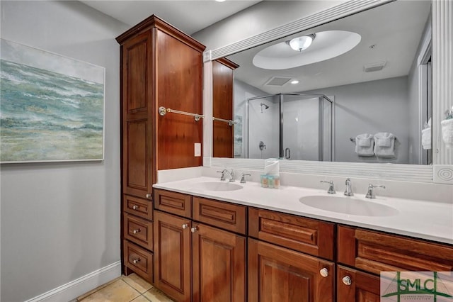 full bathroom featuring a sink, a stall shower, double vanity, and tile patterned flooring