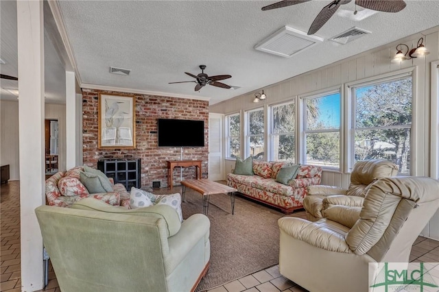 living area featuring a textured ceiling, visible vents, and a ceiling fan