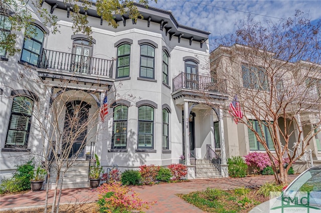 view of front of home featuring a balcony and stucco siding