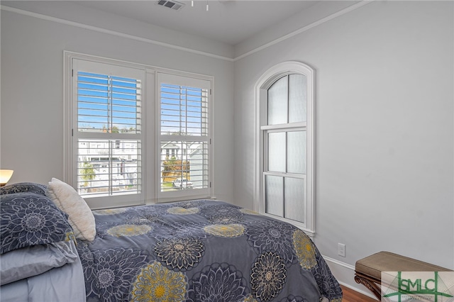 bedroom featuring visible vents and wood finished floors