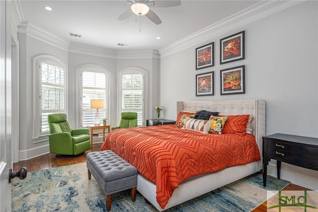 bedroom featuring visible vents, crown molding, baseboards, and wood finished floors