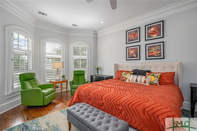 bedroom with hardwood / wood-style flooring, visible vents, and ornamental molding