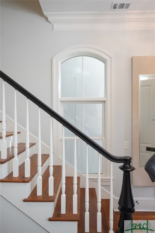 staircase featuring visible vents and crown molding