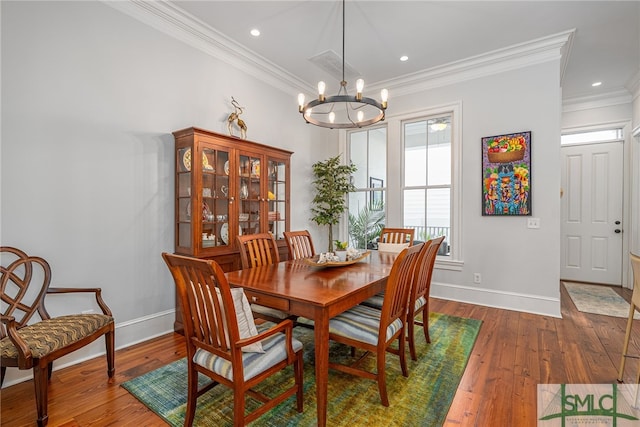 dining area with wood-type flooring, ornamental molding, and baseboards