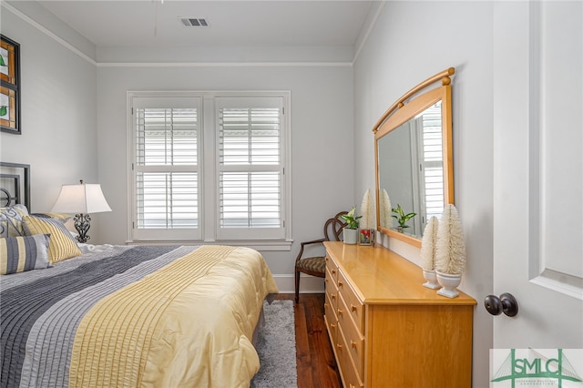 bedroom with dark wood finished floors, visible vents, and baseboards