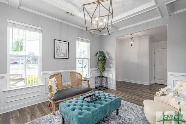 living area with wainscoting, wood finished floors, visible vents, and crown molding