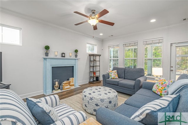 living room with recessed lighting, wood finished floors, a fireplace with flush hearth, baseboards, and crown molding