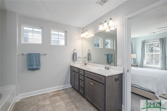 ensuite bathroom with ensuite bath, a sink, visible vents, and baseboards