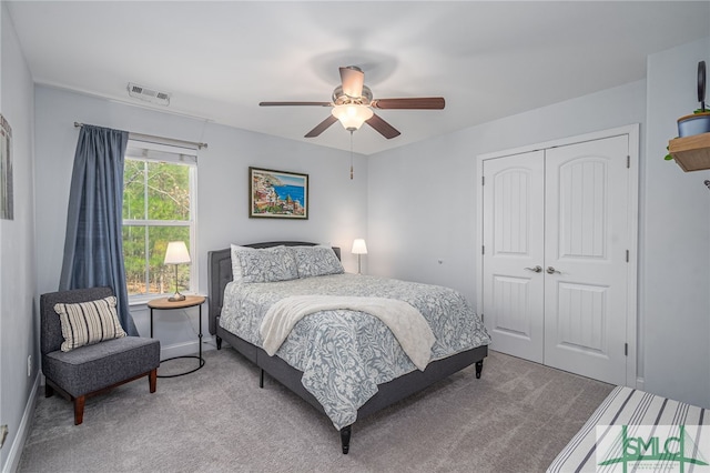 bedroom featuring carpet floors, ceiling fan, visible vents, and a closet