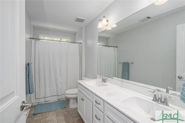 bathroom featuring toilet, visible vents, and a sink