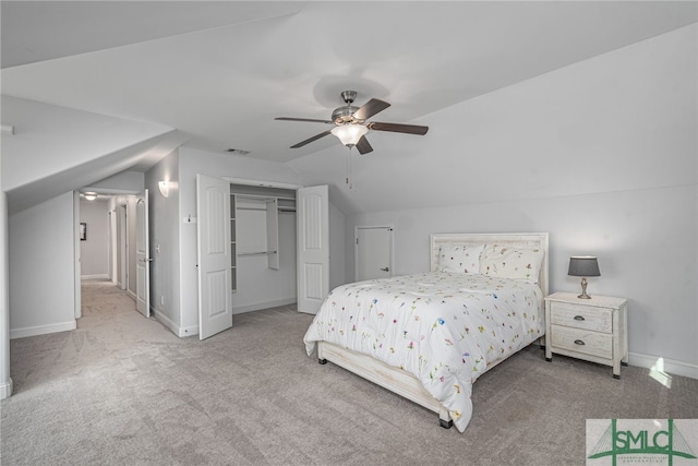 carpeted bedroom with baseboards, visible vents, lofted ceiling, ceiling fan, and a closet