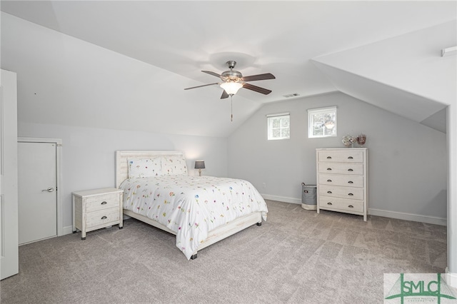 carpeted bedroom featuring a ceiling fan, lofted ceiling, visible vents, and baseboards