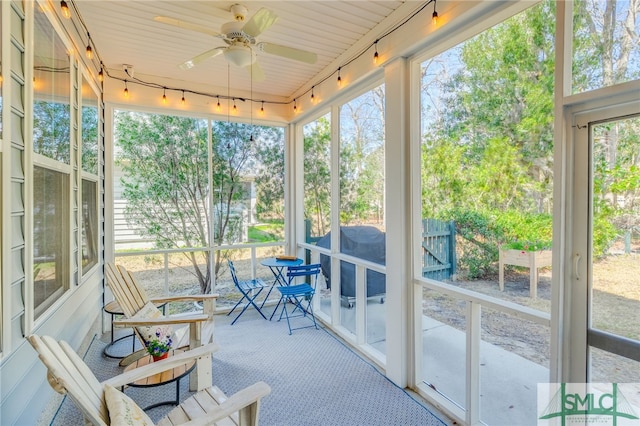 sunroom with a ceiling fan and track lighting