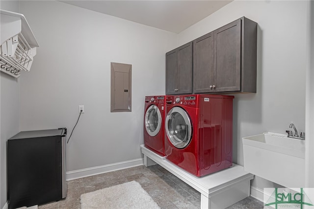 laundry area with cabinet space, electric panel, baseboards, independent washer and dryer, and a sink