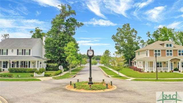 surrounding community with aphalt driveway and a lawn