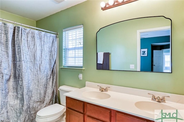 full bathroom featuring a shower with curtain, a sink, toilet, and double vanity