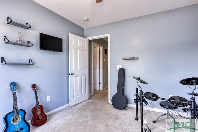 exercise area with baseboards and light colored carpet