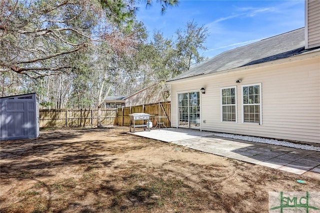 exterior space featuring an outbuilding, a shed, a patio area, and fence