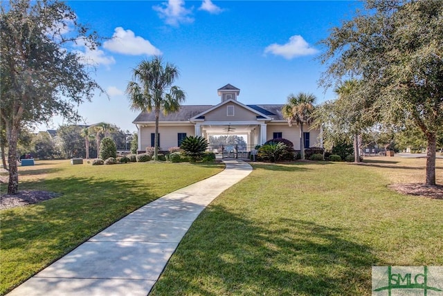 view of front of home with a ceiling fan and a front yard