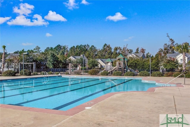 community pool featuring fence and playground community