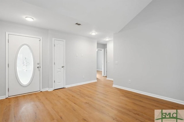 foyer entrance featuring light wood finished floors, baseboards, and visible vents