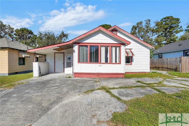 bungalow-style home featuring driveway and fence