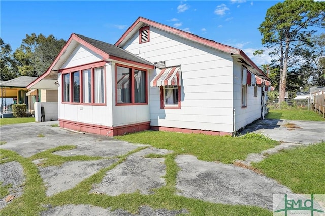 view of home's exterior with driveway and fence