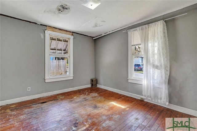 spare room featuring hardwood / wood-style flooring and baseboards