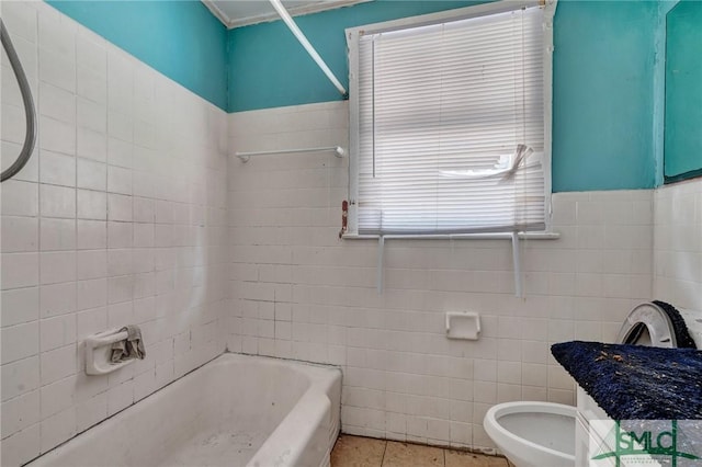 full bathroom with tile walls, toilet, wainscoting,  shower combination, and tile patterned flooring