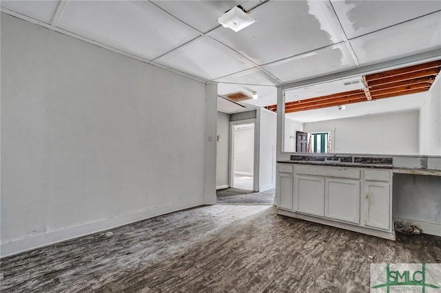 kitchen featuring dark countertops, baseboards, visible vents, and wood finished floors