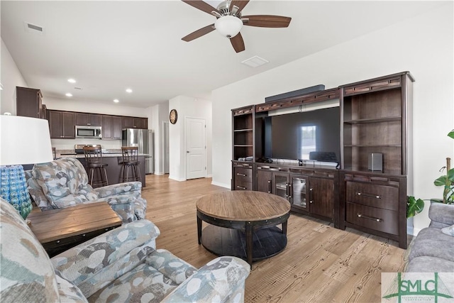 living room featuring recessed lighting, visible vents, light wood-style flooring, a ceiling fan, and baseboards