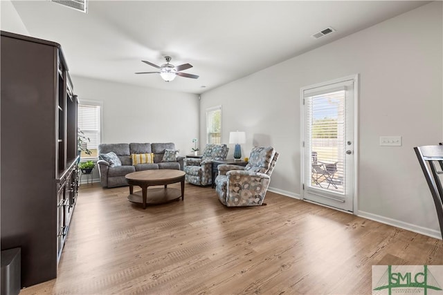 living room with a ceiling fan, baseboards, visible vents, and wood finished floors