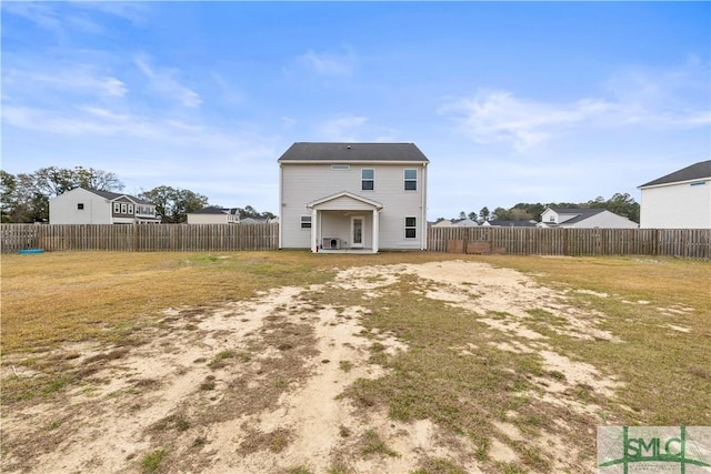 back of property with a lawn and a fenced backyard