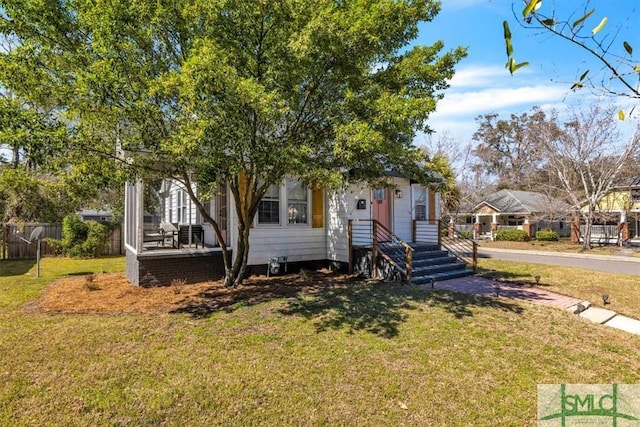 view of front of property featuring a front lawn and fence